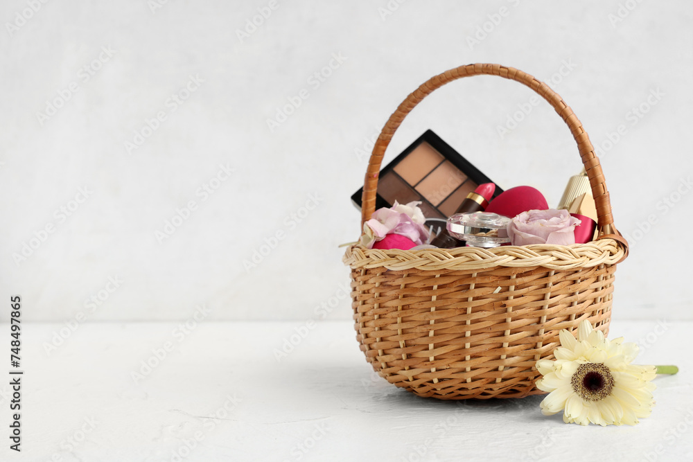 Wicker basket with decorative cosmetics, Easter eggs and flowers on white background Wicker basket with decorative cosmetics, Easter eggs and flowers on white background