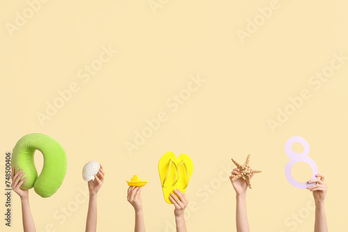 Female hands with paper figure 8, travel pillow and flip-flops on color background. International Women's Day