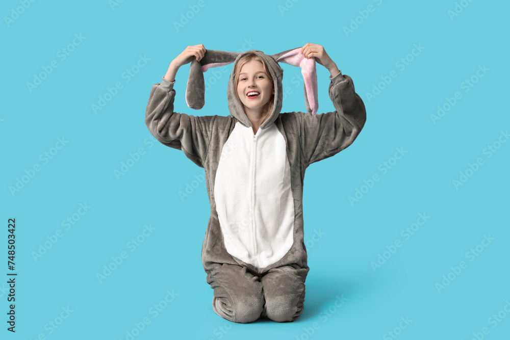 Beautiful young happy woman in bunny costume sitting on blue background. Easter celebration Beautiful young happy woman in bunny costume sitting on blue background. Easter celebration