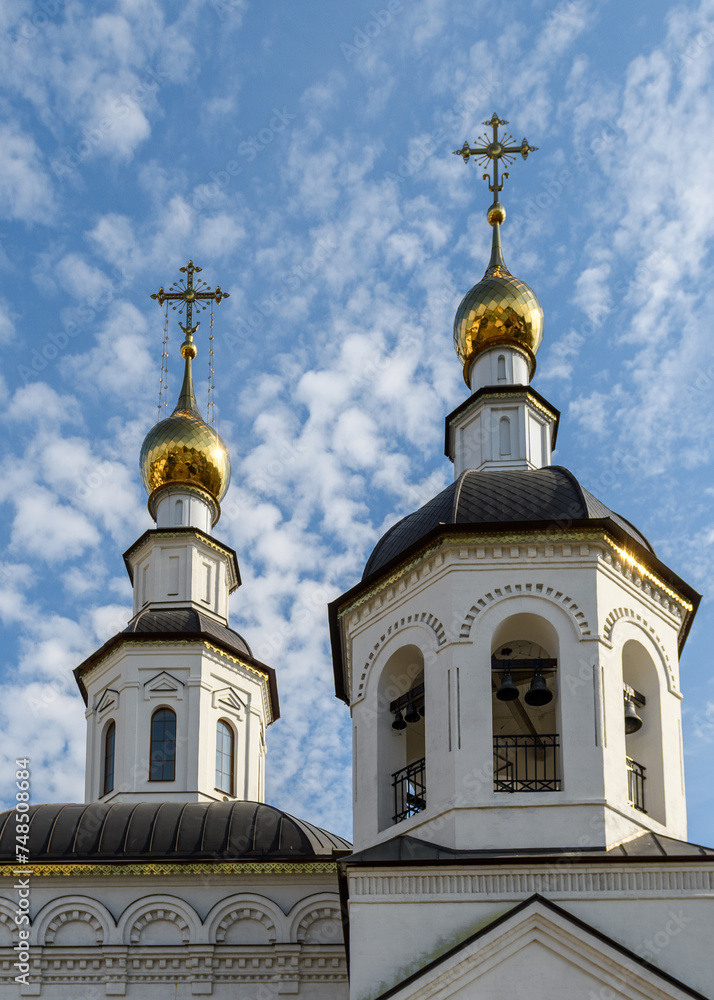 Golden domes of an Orthodox church on a sunny Easter day against the blue sky.