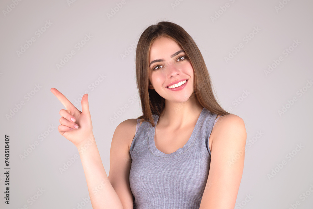 The Copy space point. Young woman pointing copy space. Studio portrait of Girl pointing away on isolated gray background. Pretty woman gesturing with fingers, showing away. The Copy space point. Young woman pointing copy space. Studio portrait of Girl pointing away on isolated gray background. Pretty woman gesturing with fingers, showing away.