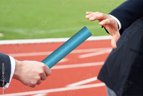 Businessman passing blue baton to partner concept succession support teamwork 