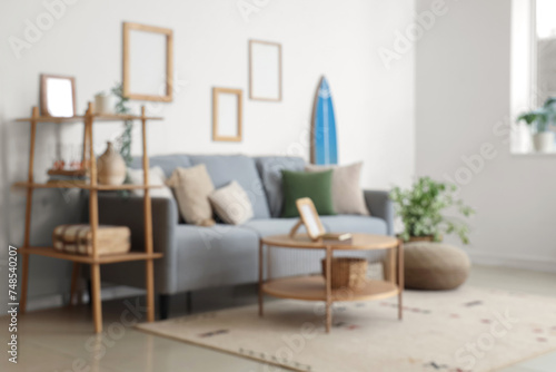 Modern comfortable interior of living room with soft sofa and table, blurred view