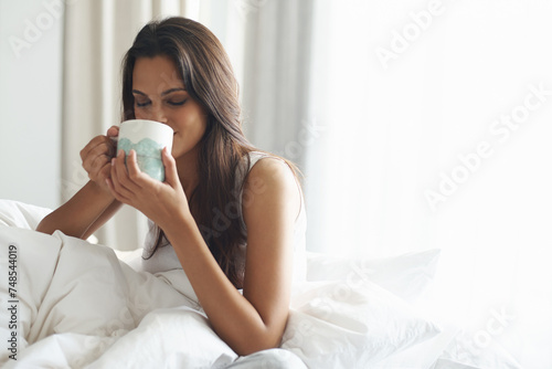 Smile  calm and woman with coffee in bedroom with caffeine to wake up in morning at home. Happy  relax and comfy young female person drinking mug of cappuccino  espresso or latte in apartment.