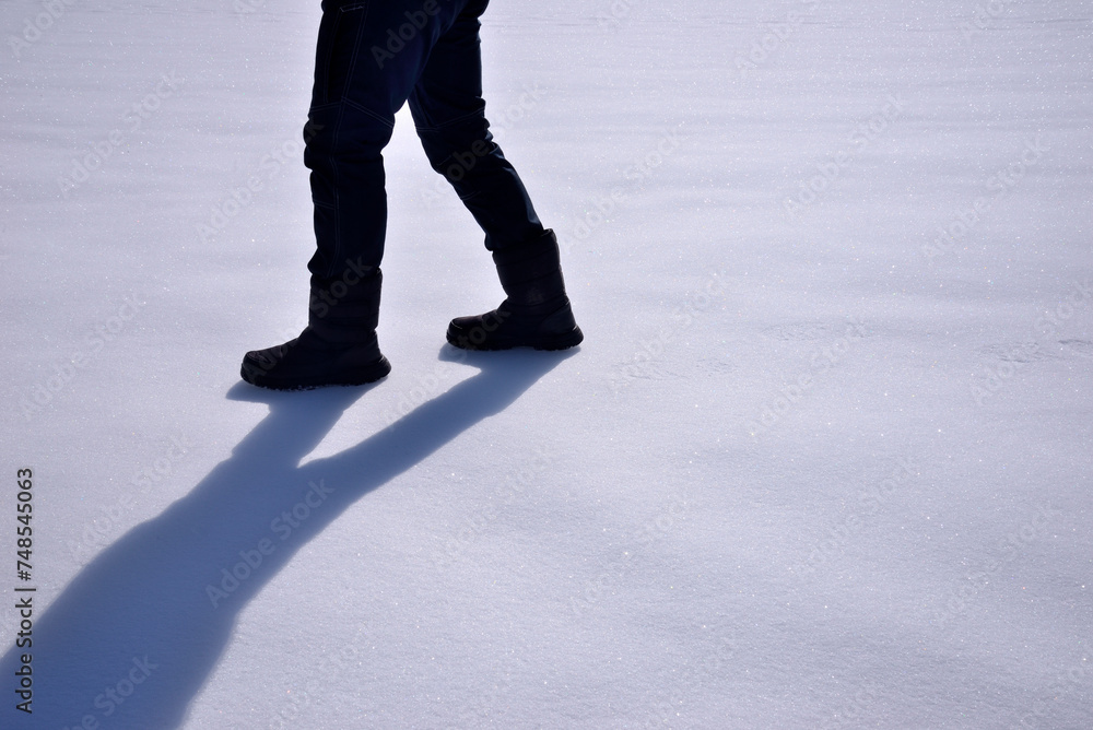 雪の上を歩く男性の足元 雪の上を歩く男性の足元