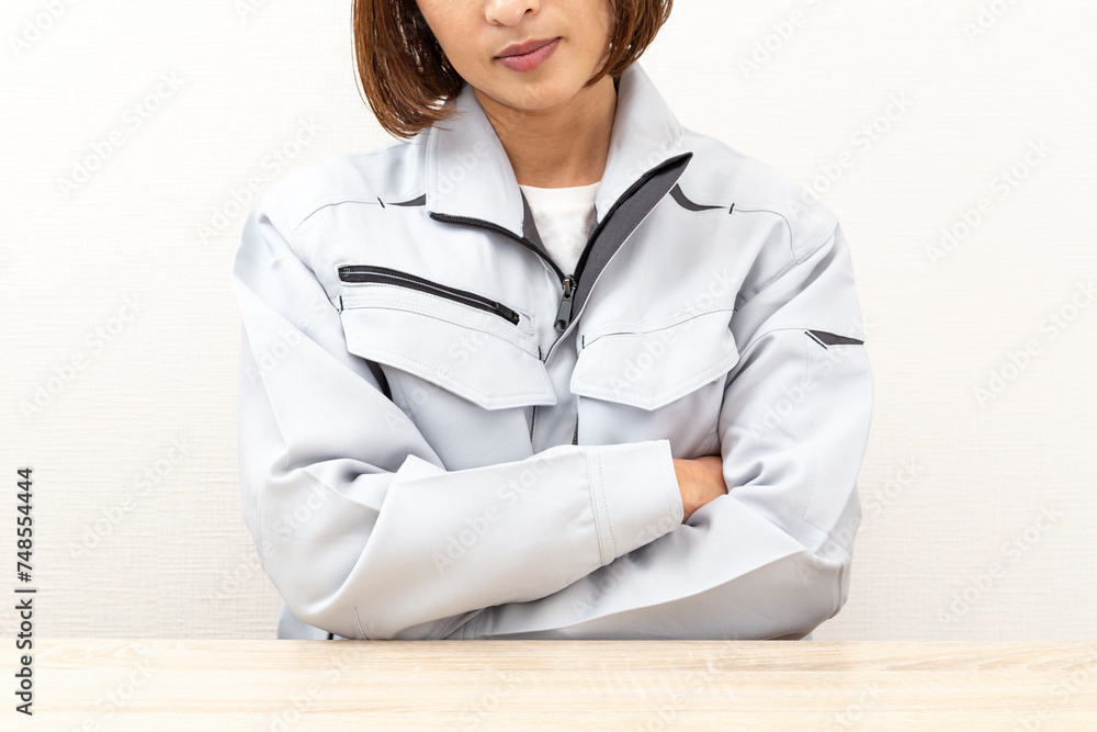 考え事をする作業服姿の女性 考え事をする作業服姿の女性