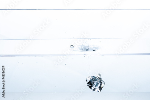 Crystal-clear water meets a plunging ice cube, creating a mesmerizing splash. Perfect for beverage advertisements or refreshing summer-themed visuals.