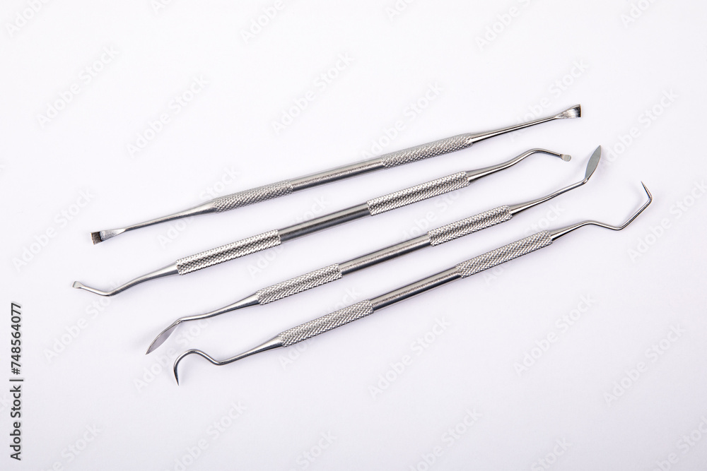Set of dental instruments on a white background. Steel Set of dental instruments on a white background. Steel