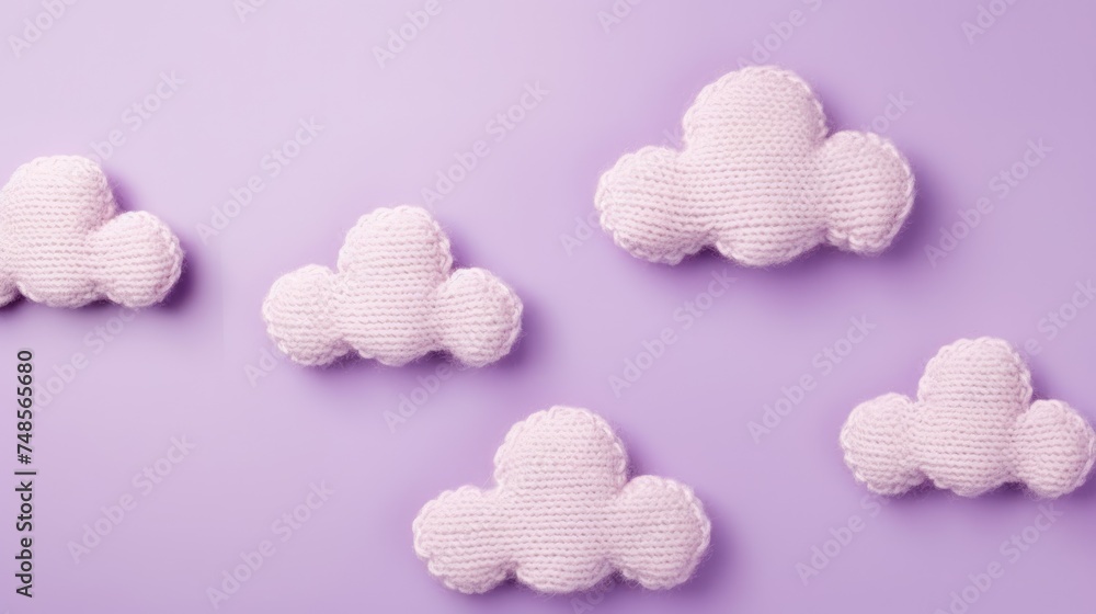 Knitted toy pink cloud on a purple background. Children's clothes and accessories. View from above.
