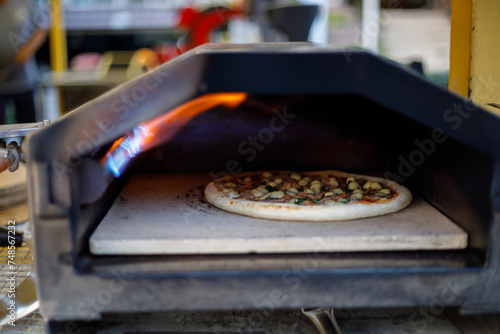 Pizza is baked in the oven near the burning.