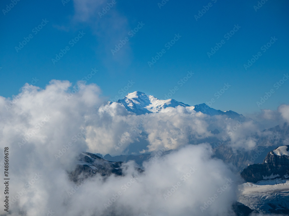 Champery, Switzerland - September 10th 2023: Distant view towards Mont Blanc peak through clouds