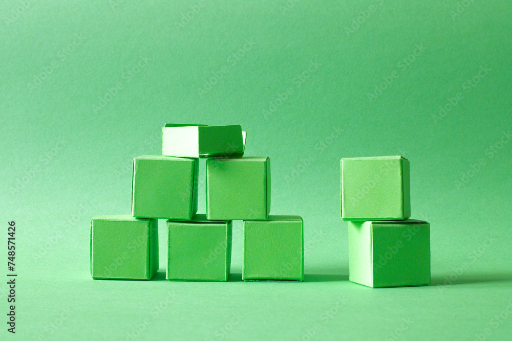 Green Cubes Organized in a Pyramid Formation on Uniform Teal Green Background Representing Eco-Friendly Development Green Cubes Organized in a Pyramid Formation on Uniform Teal Green Background Representing Eco-Friendly Development