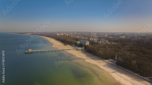 Ko  obrzeg pier on a sunny February afternoon. Windless weather  calm sea without a single wave  tourists strolling on the pier.