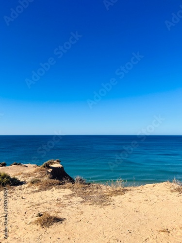 Sandstone rocky coast  blue ocean horizon  clear sky  ocean bay