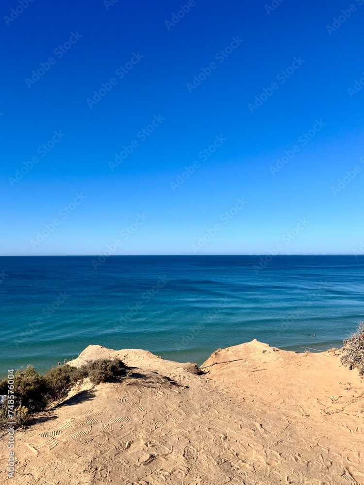 Sandstone rocky coast, blue ocean horizon, clear sky, ocean bay Sandstone rocky coast, blue ocean horizon, clear sky, ocean bay