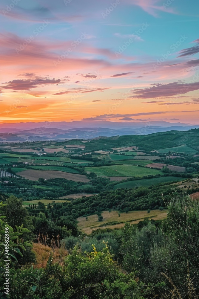 A peaceful sunset view of the countryside from a hilltop. Ideal for nature and landscape themes