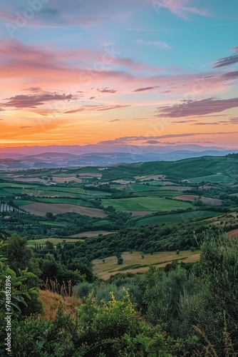 A peaceful sunset view of the countryside from a hilltop. Ideal for nature and landscape themes