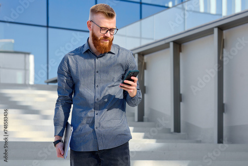 Принти на полотні Successful aspiring businessman man with red beard enjoys warm weather while wal