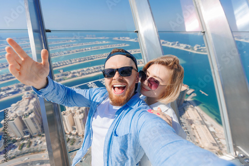 Selfie photo of happy couple young man and woman tourists background skyscrapers in Dubai, UAE tourism travel
