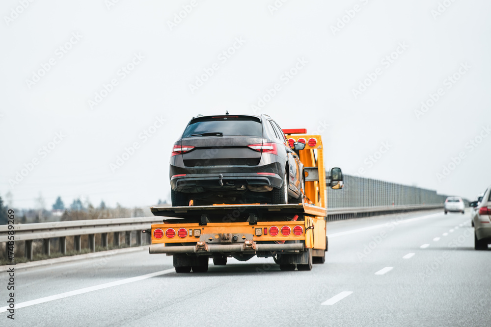 Emergency roadside assistance in action as a tow truck carries a broken down SUV on the highway. Emergency roadside assistance in action as a tow truck carries a broken down SUV on the highway.