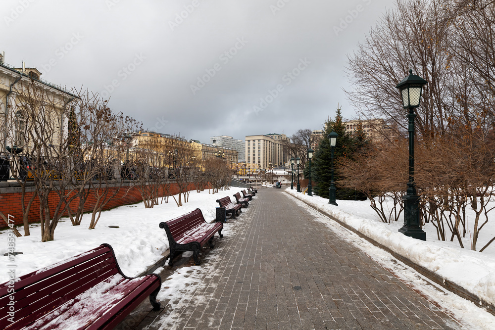 Snowy winter city street with benches and lanterns, Moscow, Russia