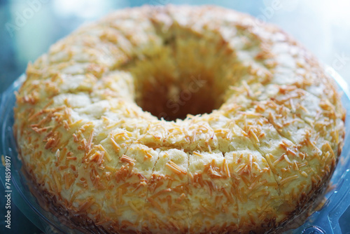 Homemade round sponge cake in a plastic container so soft and delicious with ingredents: eggs, flour and milk. Close-up of round sponge cake on the table
