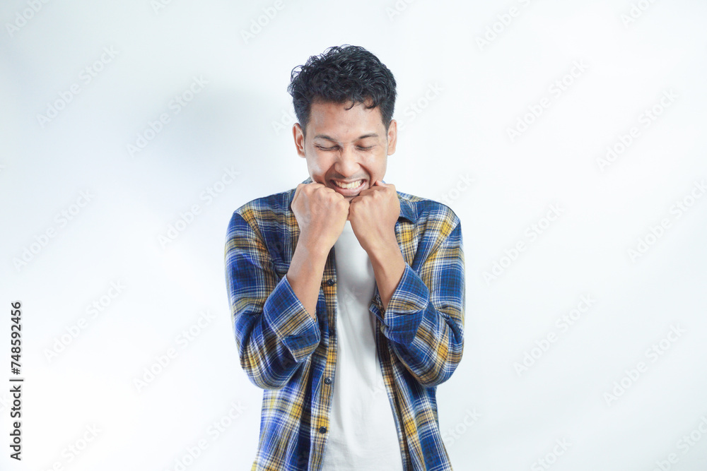 Adult Asian man clenching both hands showing excited expression Adult Asian man clenching both hands showing excited expression