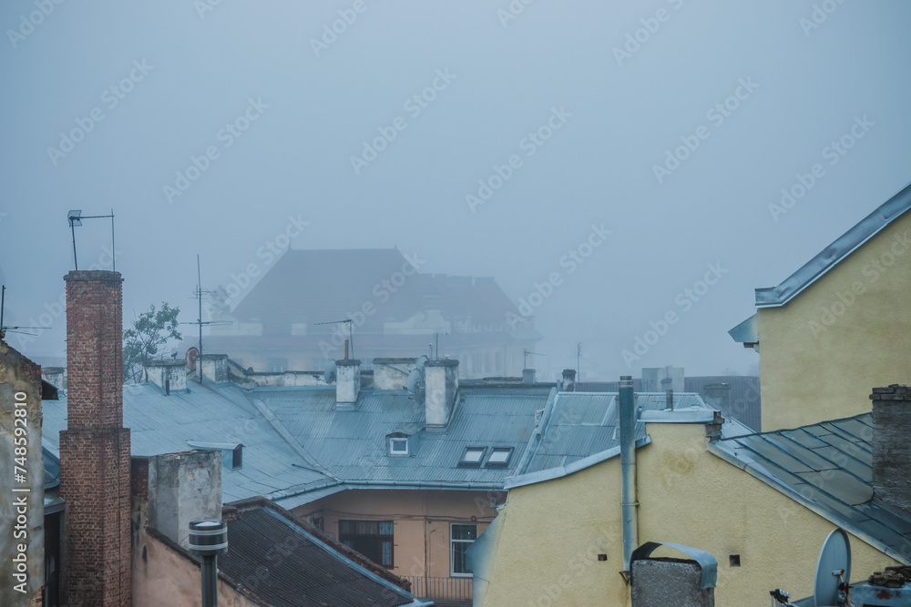 Old town in the fog. Roofs of houses on a foggy morning in Lviv. Old houses in the fog. Ukraine.