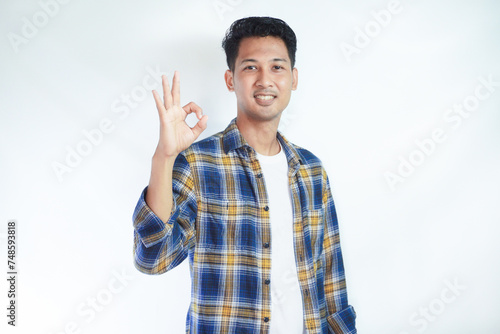 Adult Asian man smiling friendly and giving 