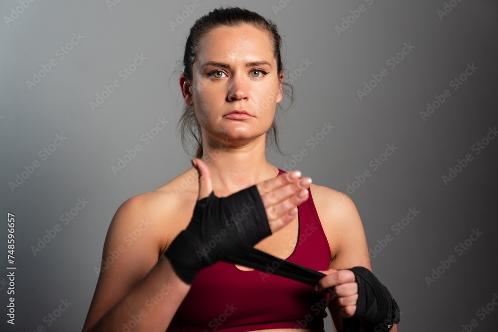 Portrait of a sporty female boxer on a grey background Portrait of a sporty female boxer on a grey background