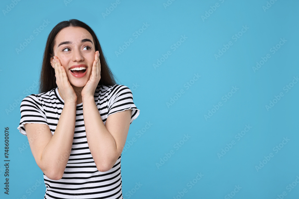 Portrait of happy surprised woman on light blue background. Space for text Portrait of happy surprised woman on light blue background. Space for text