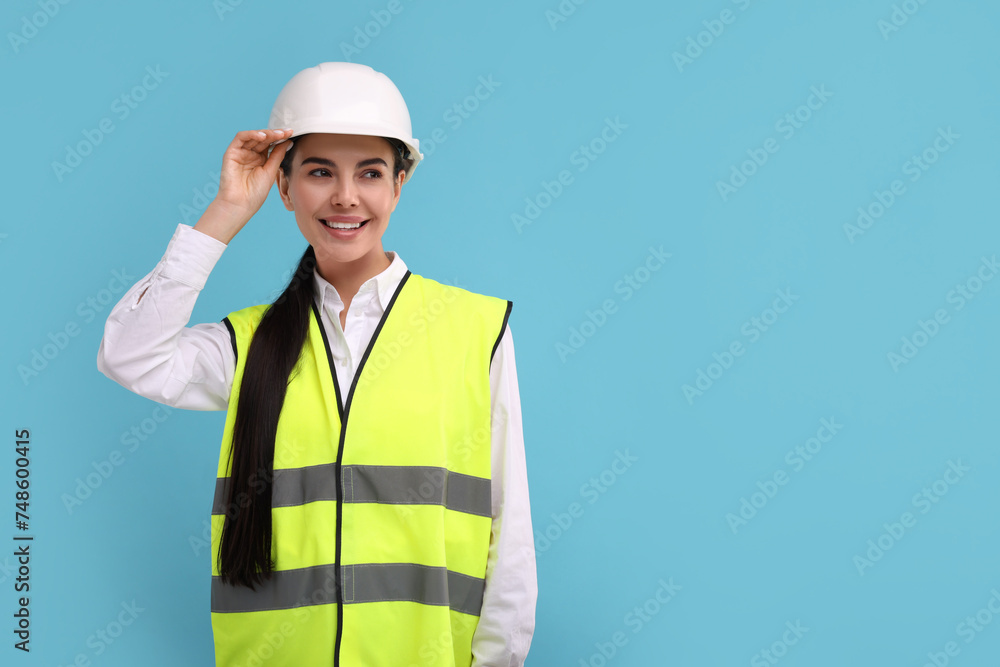 Engineer in hard hat on light blue background, space for text Engineer in hard hat on light blue background, space for text