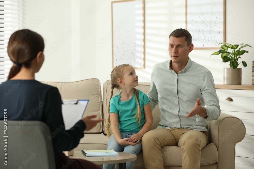 Little girl and her father on appointment with child psychotherapist indoors - obrazy, fototapety, plakaty 