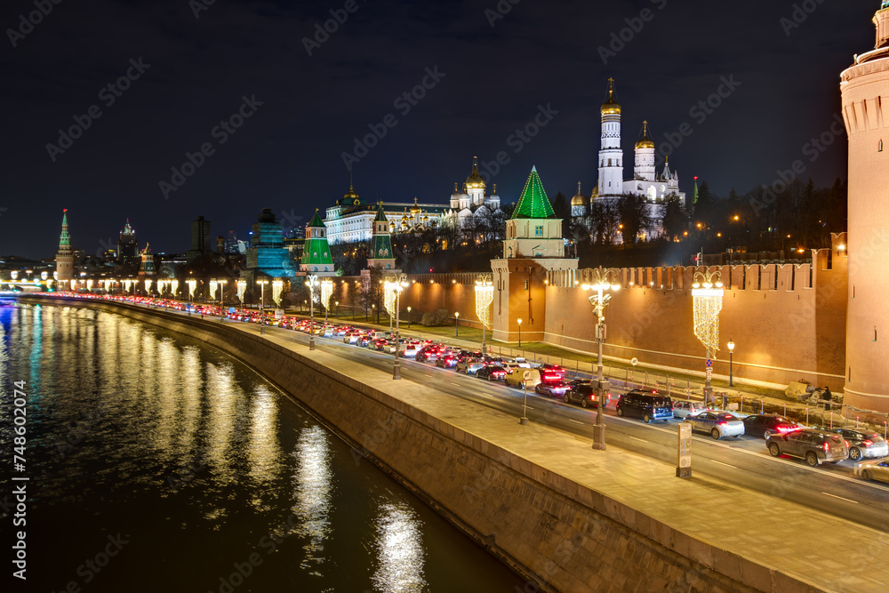 Moscow, Russia. Evening view of the Moscow River, Kremlin embankment and the Moscow Kremlin. Historical center of Moscow. There are many cars on the roadway in a traffic jam.