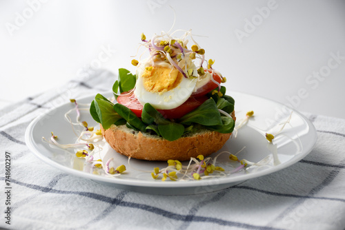 sandwich with egg, tomato, lettuce and sprouts; homemade healthy breakfast
