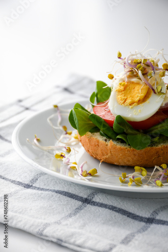 sandwich with egg, tomato, lettuce and sprouts; homemade healthy breakfast