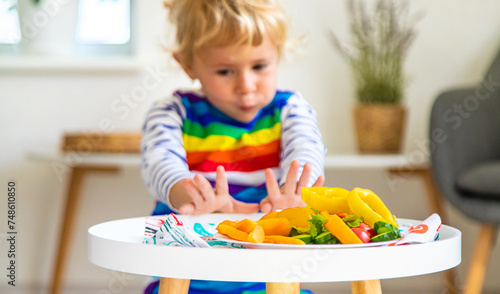 Child eats vegetables at home. Selective focus.