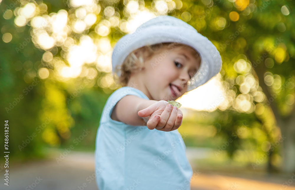 A child catches a butterfly in nature. Selective focus. A child catches a butterfly in nature. Selective focus.
