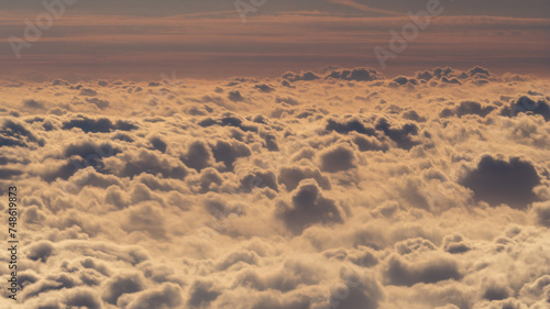Captured from a plane  the photo showcases clouds resembling cotton  their billowy formations creating a picturesque scene in the vast expanse of the sky  evoking a sense of tranquility and wonder