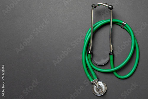 Top view of green medical stethoscope on colorful background with copy space. Medicine equipment concept photo