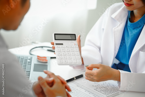 Engaging dental consultation with a female model discussing men's dental appointments at a professional desk meeting, emphasizing oral health and dental care for men. Show medical costs in calculator photo