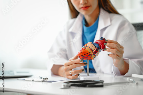 Female doctor provides crucial guidance to a male patient in a clinic room, discussing heart attack prevention, prescribing medication, and emphasizing well-being at the appointment desk. photo