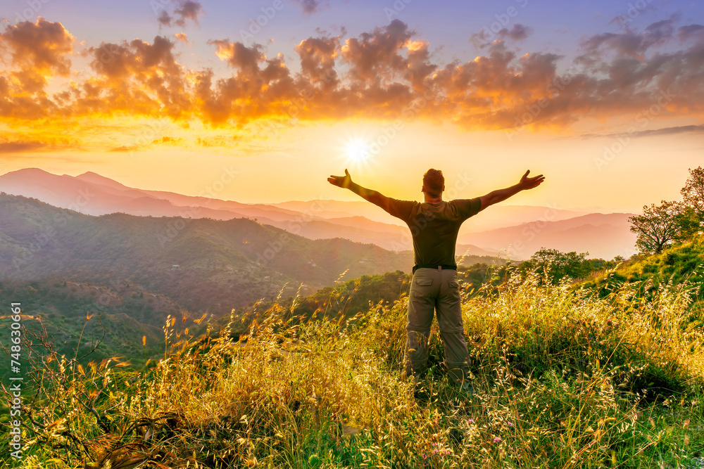 rejoicing man with beautiful scenic mountain sunset landscape on background. happy man watching amazing evening sunset rejoicing man with beautiful scenic mountain sunset landscape on background. happy man watching amazing evening sunset