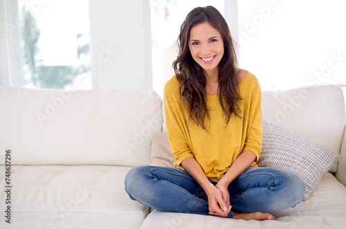 Woman, smile and sitting in portrait on sofa to relax in home with pride, holiday and confidence in living room. Person, happy and break on vacation in lounge with couch at apartment in Barcelona