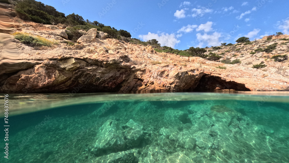 Underwater split photo of paradise fjord rocky bay of Tourkopigado, Iraklia island, small Cyclades, Greece