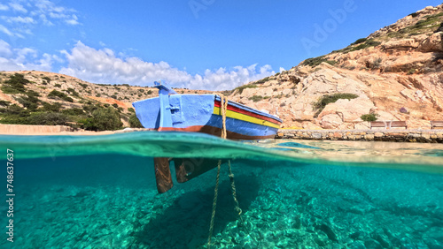 Underwater split photo of traditional fishing boat anchored in crystal clear sea of Mykonos island, Cyclades, Greece © aerial-drone