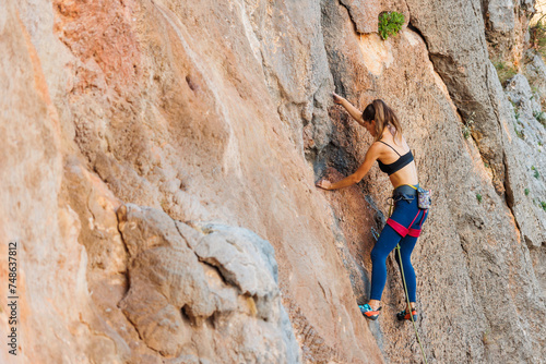 rock climber girl. rock climber girl climbs an overhanging rock.