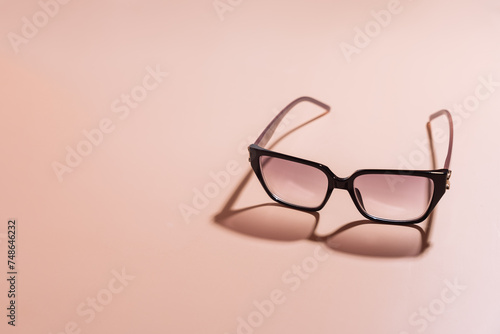 Sunglasses with black frames on pink background.