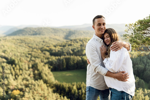 happy young pregnant couple in the mountains. husband and pregnant wife in nature. happy relationship concept
