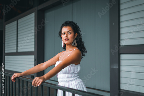 Colombian woman in stylish white dress, striking a pose in a chic interior setting